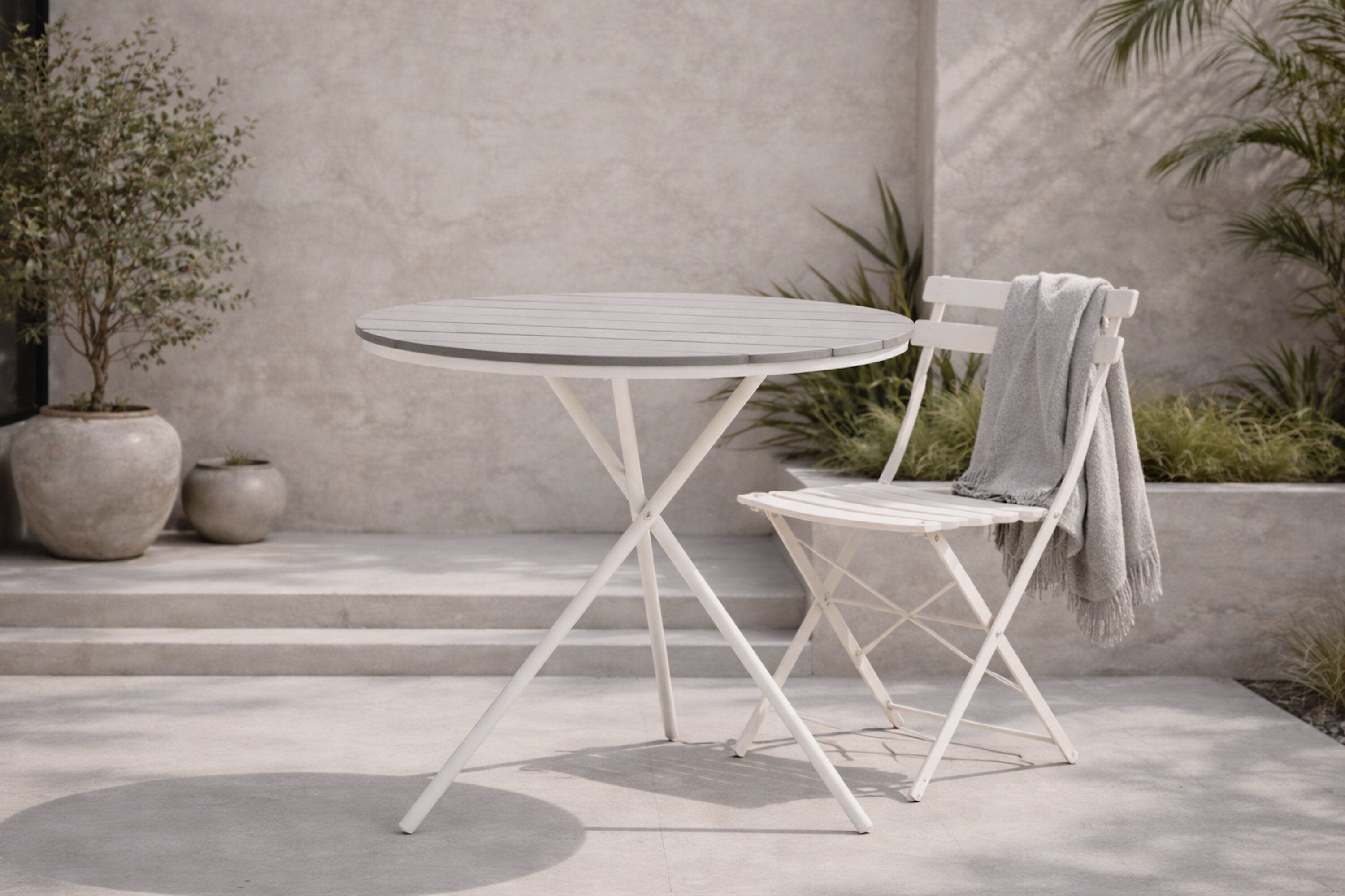 Garden table Malari - a round dining table with Aintwood tabletop and a metal frame