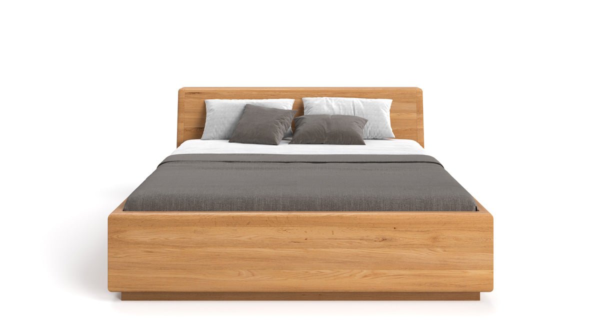 Designer wooden bed Calveno made of solid Oak with storage and slanted headboard