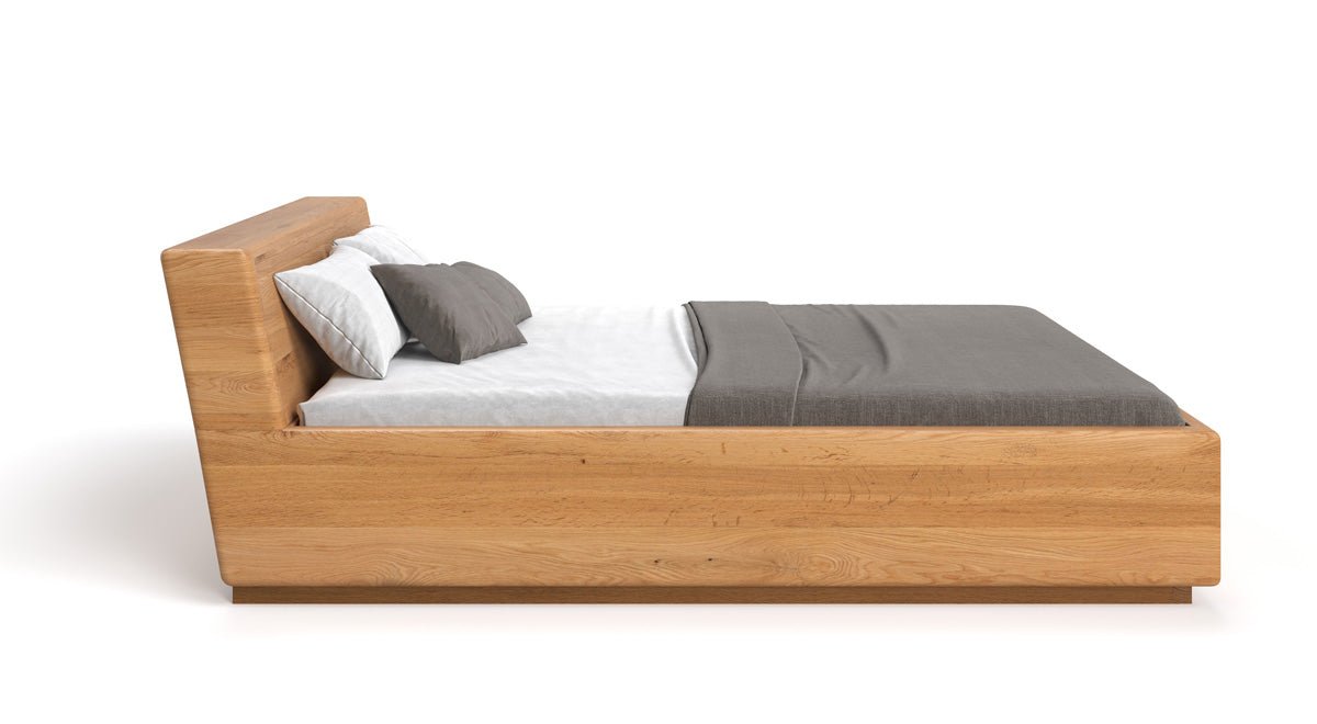 Designer wooden bed Calveno made of solid Oak with storage and slanted headboard